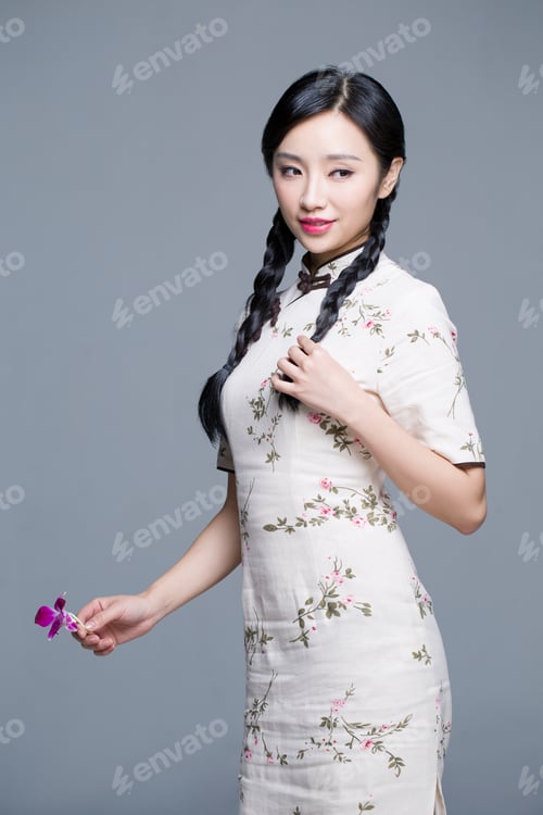 Preview: Young beautiful woman in traditional cheongsam with orchid