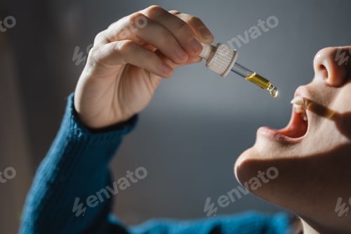 Preview: Sublingual cbd hemp oil - Woman taking sublingual cannabidiol for anxiety alternative treatment