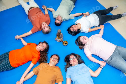 Preview: Disabled people lying on the floor meditating together