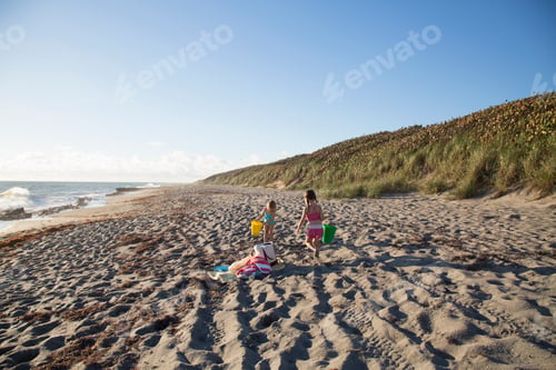 Preview: Two sisters playing with toy buckets on beach, Blowing Rocks Preserve, Jupiter Island, Florida, USA