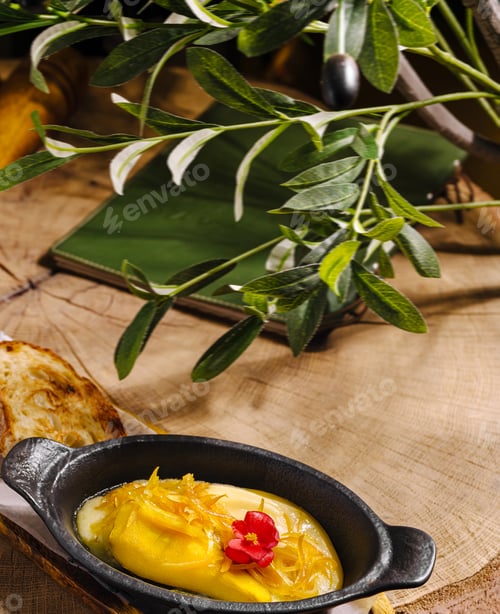 Preview: Delicious dish served in cast iron with fresh bread on wooden table