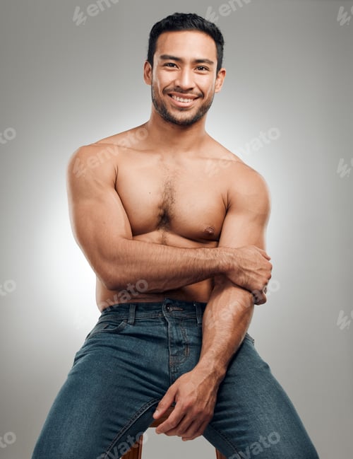 Preview: Shy Whats that. Shot of a handsome young man sitting on a stool in the studio and posing shirtless.