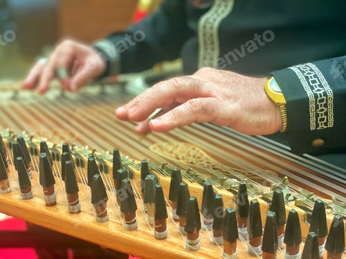 Preview: An unrecognizable musician plays a traditional string music instrument called a qanun skillfully