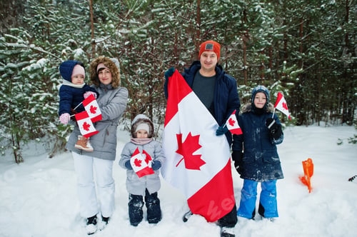Preview: Family holding flag of Canada on winter landscape.