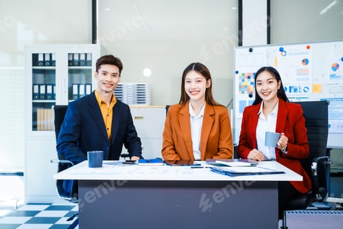 Preview: Three Asian professionals meet in boardroom, discussing strategy, future goals, corporate growth.