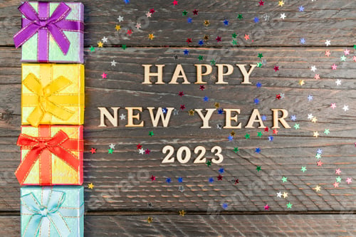 Preview: Multicolored gift boxes. New year presents on wooden table. Tex Happy new year 2023. greeting car