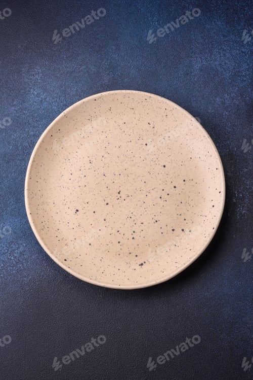 Preview: Round empty colored ceramic plate on concrete texture background