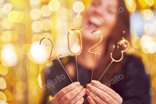 Preview: Woman holding 2023 sparklers at new year eve