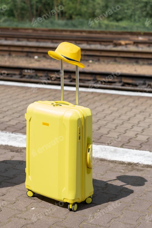 Preview: Suitcase with hat at railway station. Vacation and travel during holidays and weekends.
