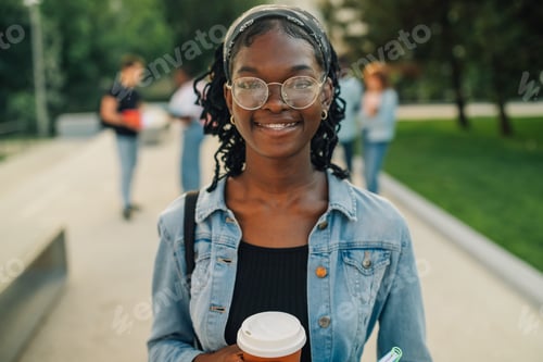 Preview: Close up of happy diverse adolescent college girl at university campus