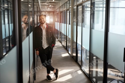 Preview: Smiling man facing camera in hallway of office