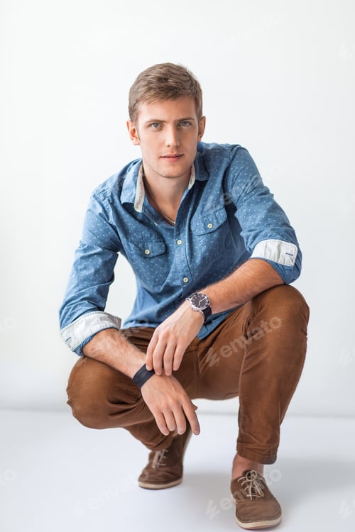 Preview: Handsome serious man sitting on the floor