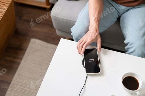 Preview: person trying to charge his smartphone on the wireless battery charger.