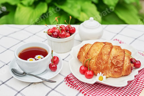 Preview: Tea, Croissant, and Cherries on a Table