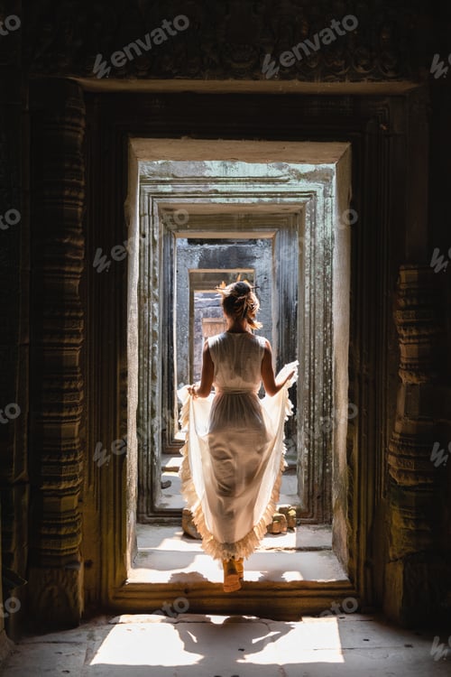Preview: Young woman wearing white robe dress in ancient Khmer ruins, Angkor Wat