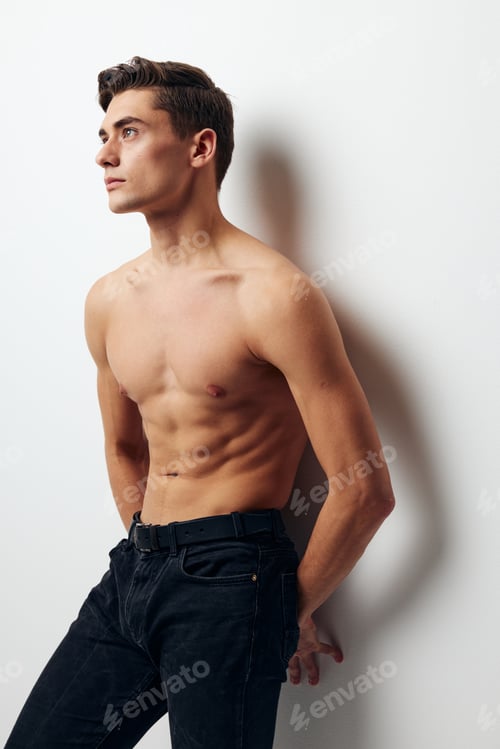 Preview: A man in trousers with a bare torso leaned against the wall