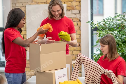 Preview: Volunteers in red thsirts taking part if donations distribution