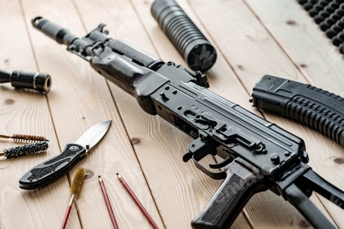 Preview: Disassembled rifle with cleaning tools on table of weapons workshop