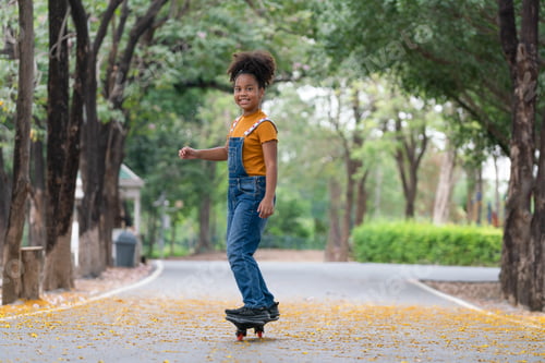 Preview: Happy African American girl playing skateboard in park, Sport outdoor for kid.