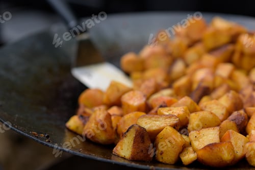 Preview: Chunks of fried potatoes in a large skillet during the street food festival.