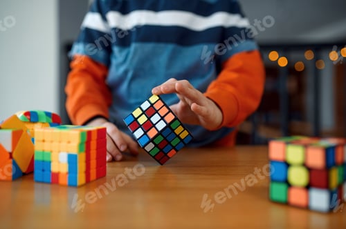 Preview: Boy holds puzzle cube, selective focus on hand