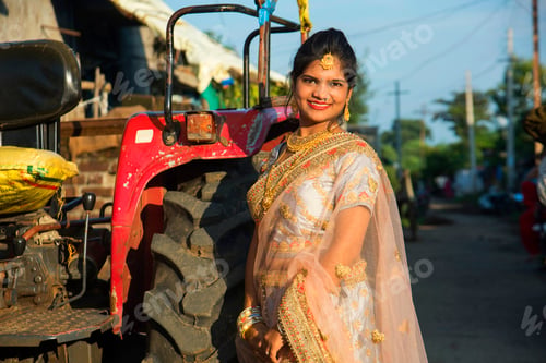 Preview: Beautiful Indian bride with tractor in village.