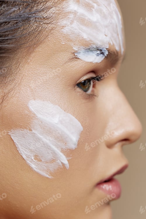 Preview: brunette skin care by using white mask on the face close-up make-up