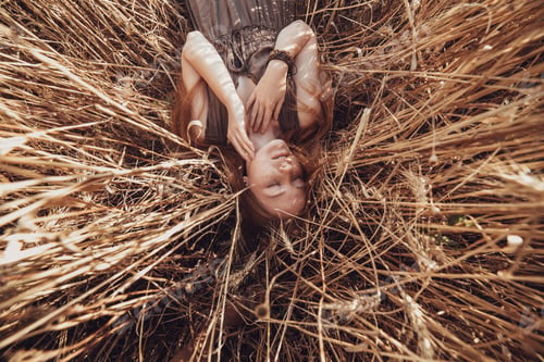 Preview: Young ginger woman in the wheat field looking relaxed.