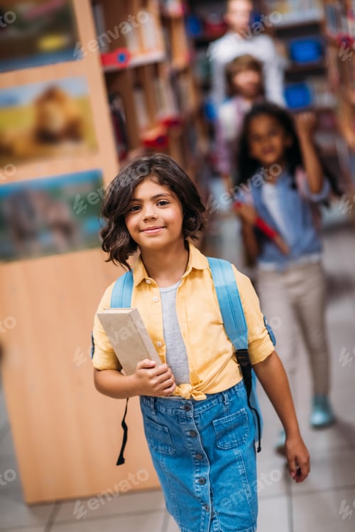 Visualização: adorável garotinha com livro na biblioteca