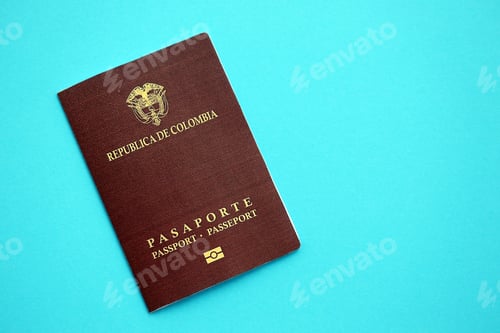 Preview: Colombia Republic red passport on light blue table background. Concept of travel and tourism