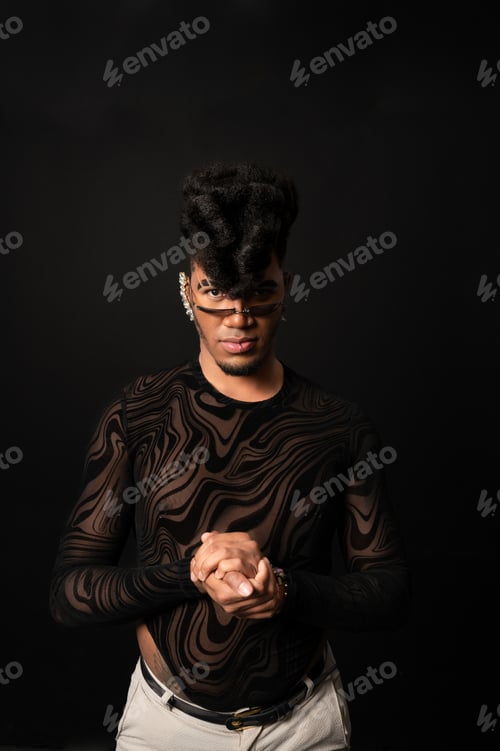 Preview: Young stylish dancer posing with folded hands on black background