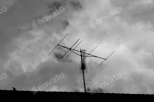 Preview: Monochrome shot of antenna against dark cloudy sky background