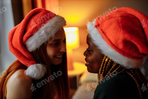 Preview: mixed race couple in santa claus hat at home in evening