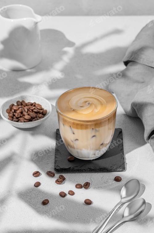 Preview: Dalgona coffee. Whipped instant coffee in a glass with ice on a slate board on a gray background