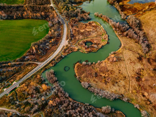 Preview: Aerial view of winding river and road in golden colored fall forest