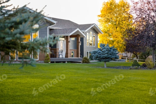 Preview: Beautiful two-story house surrounded by lush green grass and tall trees in the backyard