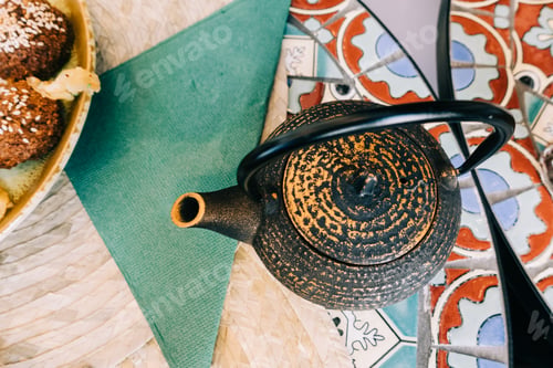 Preview: Teapot near plate with delicious food on table