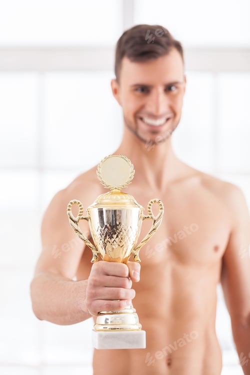 Preview: I am a winner! Cheerful young muscular man holding a golden trophy in his hand and smiling