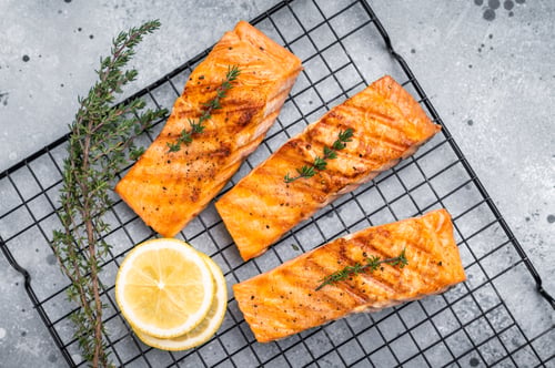 Preview: Grilled salmon fillet steak, roast fish on a rack. grey background. top view
