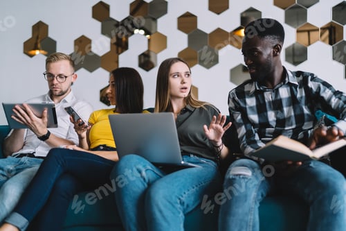 Preview: Multiracial group of people talking and sitting on sofa