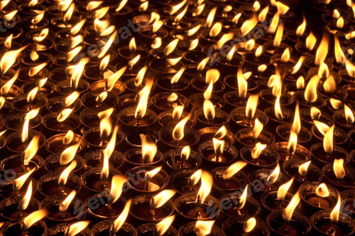 Preview: Butter lamps with flames near Bodhnath stupa in Kathmandu, Nepal