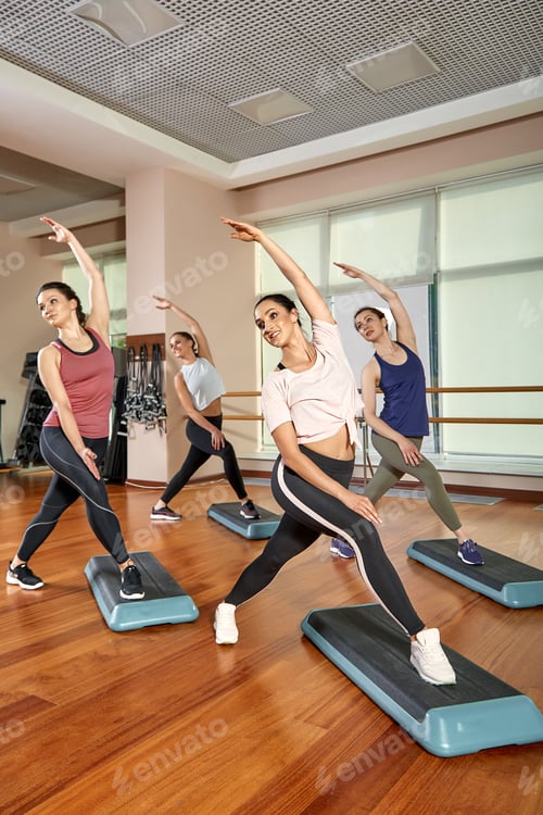 Preview: A group of sporting young people in sportswear, in a fitness room, doing push-ups or planks in the