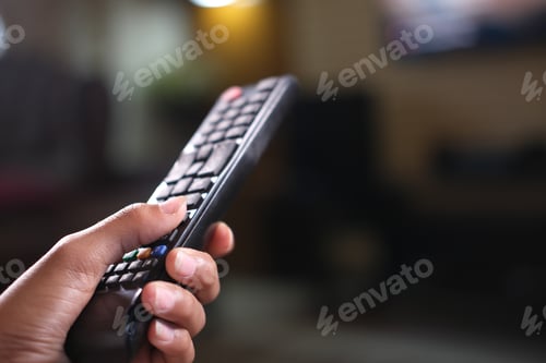 Preview: close up of man hand holding tv remote.