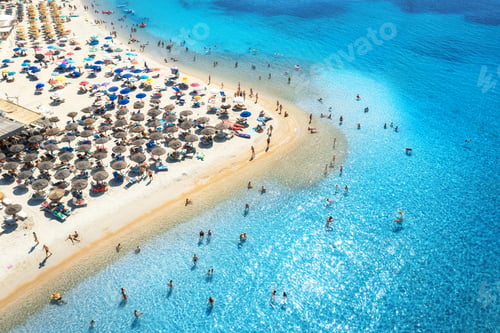Preview: Aerial view of colorful umbrellas on beach, people in blue sea