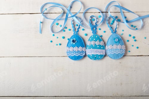 Preview: Handmade patchwork blue felt easter eggs on white wooden table
