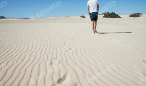 Preview: A lone figure walks across the desert sands, leaving a trail of footprints
