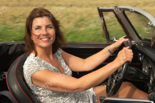 Preview: Mid aged woman in sports car