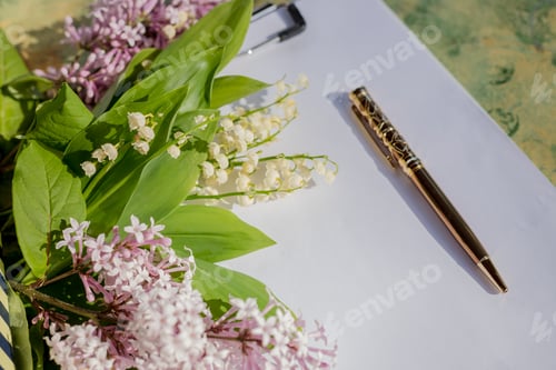 Preview: blogger or freelancer workspace with a mockup clipboard with lilac flowers, new goal. new year plan