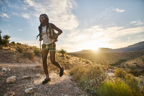 Preview: woman hiking at Red Rock Canyon during sunset with backpack