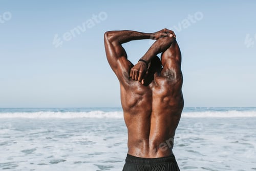 Preview: Fit man stretching at the beach